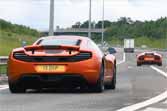 50 Supercars Accelerating Onto A Motorway